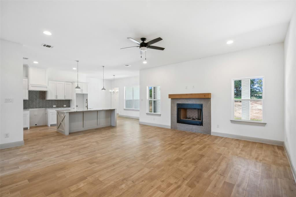 191 Lucky Ridge Lane Boyd, TX 76023 - Photo 10 of 38 a view of an empty room with kitchen and fireplace