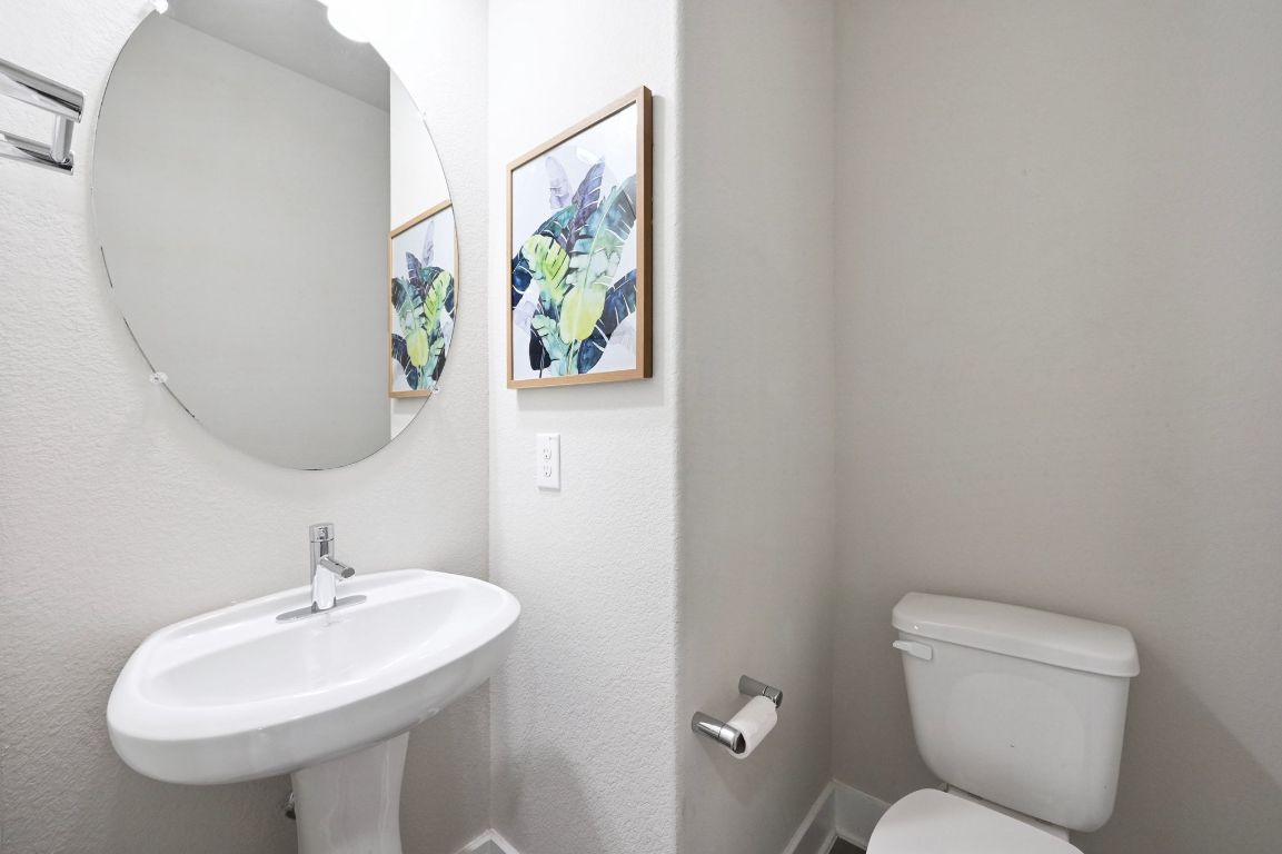 2108 Hermia Street Austin, TX 78741 - Photo 16 of 28 a bathroom with a toilet a sink and a mirror