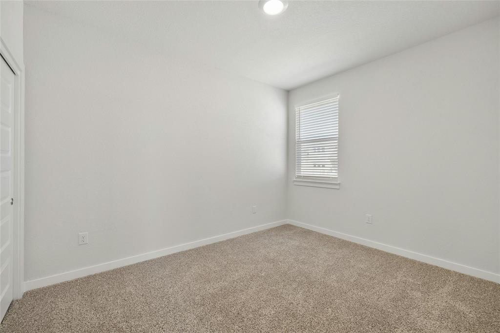 113 Shadow Oak Cove Georgetown, TX 78628 - Photo 31 of 40 An inviting room awaits personal touches, featuring a window for natural light and soft carpeting underfoot.