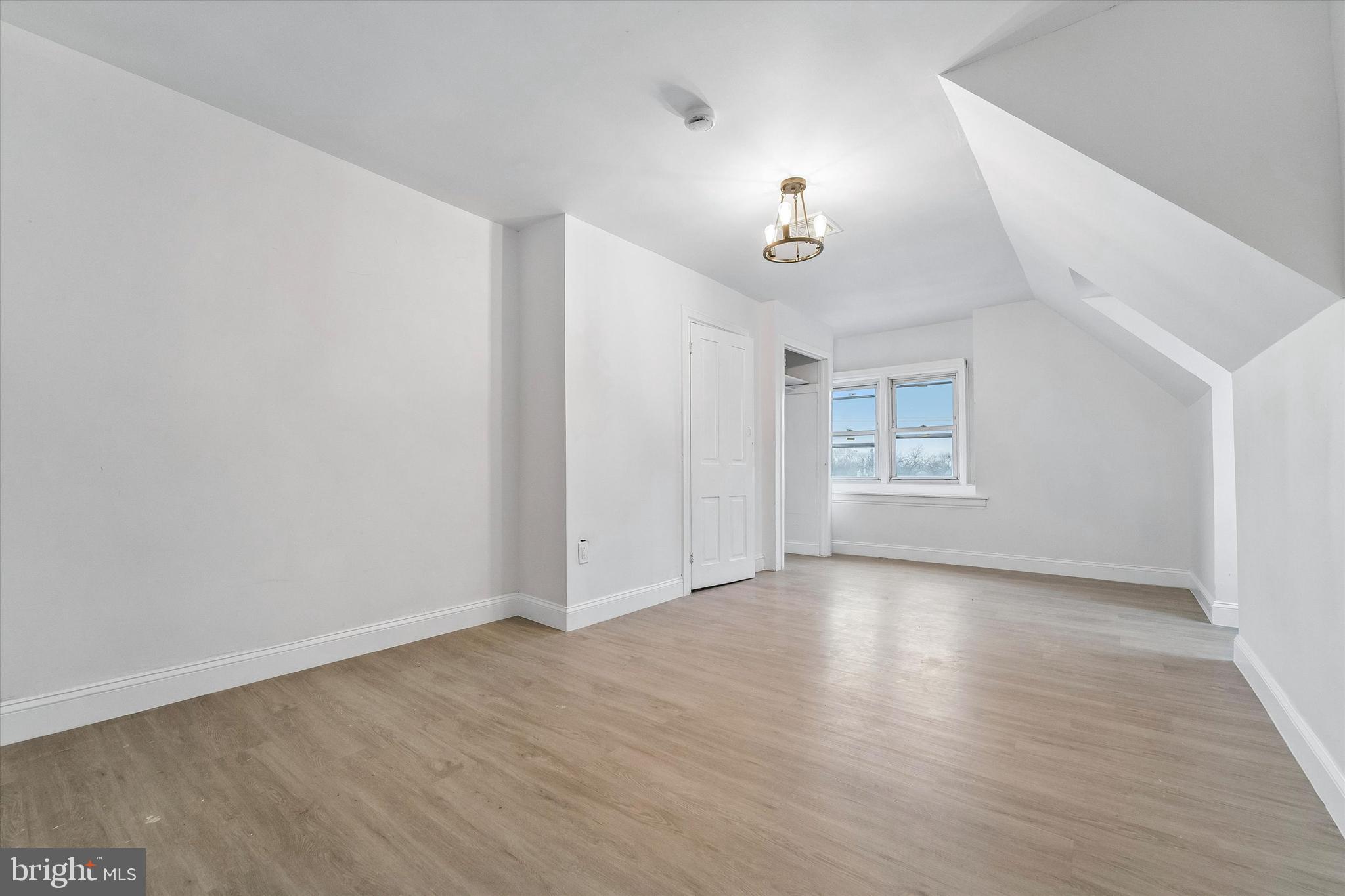 79 High Street, Unit 2 Philadelphia, PA 19144 - Photo 13 of 17 an empty room with wooden floor chandelier and windows