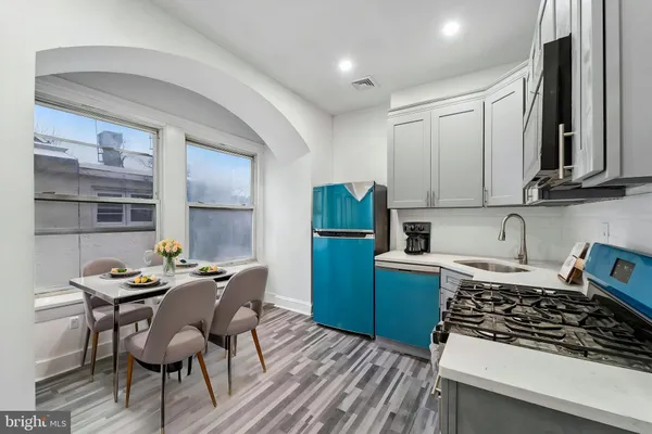 a kitchen with granite countertop a stove a sink and a refrigerator