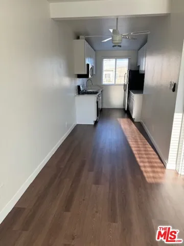a view of a kitchen with wooden floor a sink and windows