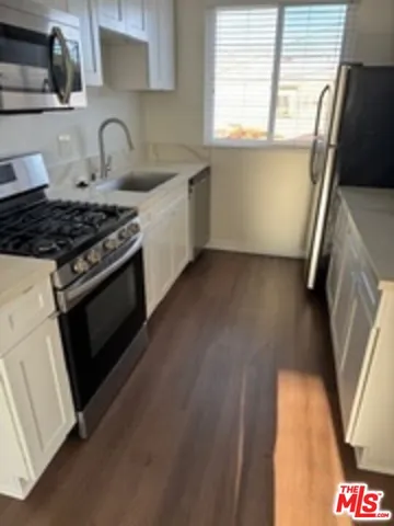 a kitchen with granite countertop a stove and a sink