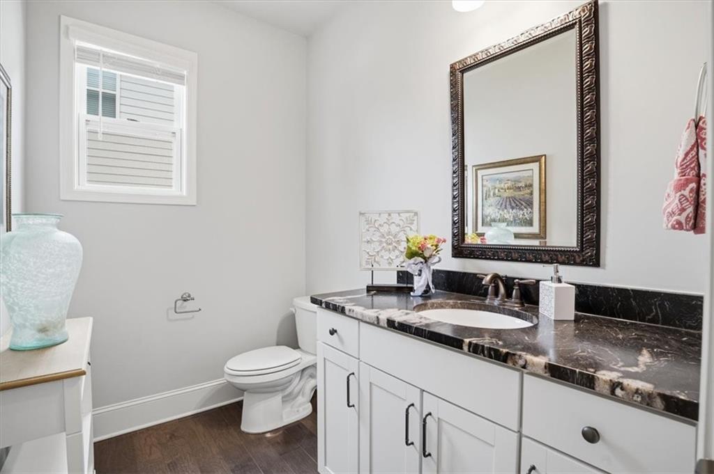 6265 Privet Way Cumming, GA 30028 - Photo 13 of 47 a bathroom with a granite countertop toilet a sink and a mirror