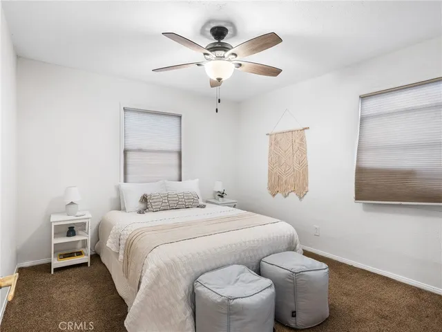 a bedroom with a bed and a ceiling fan