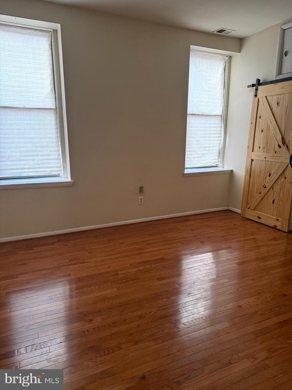 2005 Madison Avenue, Unit 2 Baltimore, MD 21217 - Photo 13 of 16 an empty room with wooden floor and windows