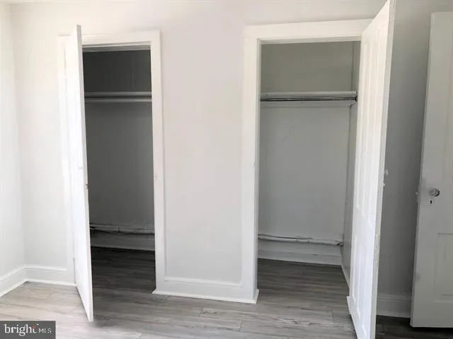a view of walk in closet with wooden floor