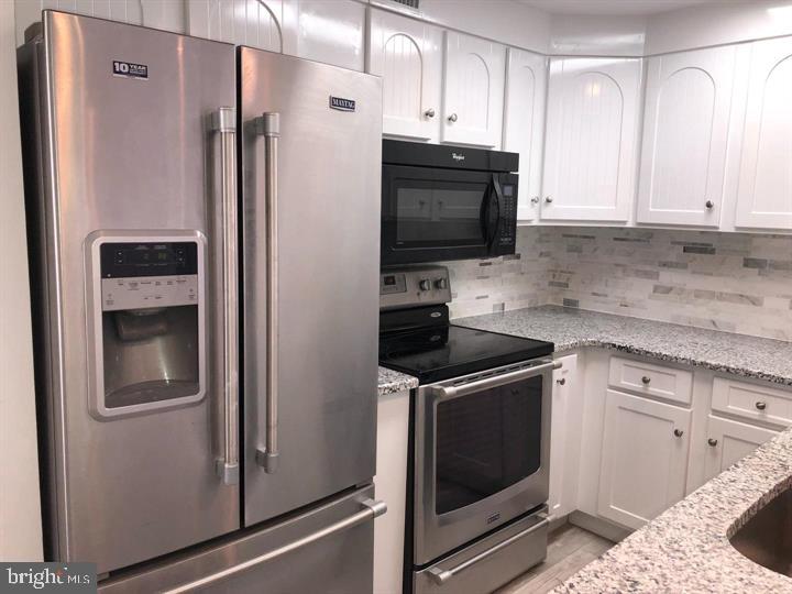 75 South Main Street Yardley, PA 19067 - Photo 7 of 29 a kitchen with stainless steel appliances white cabinets and a refrigerator