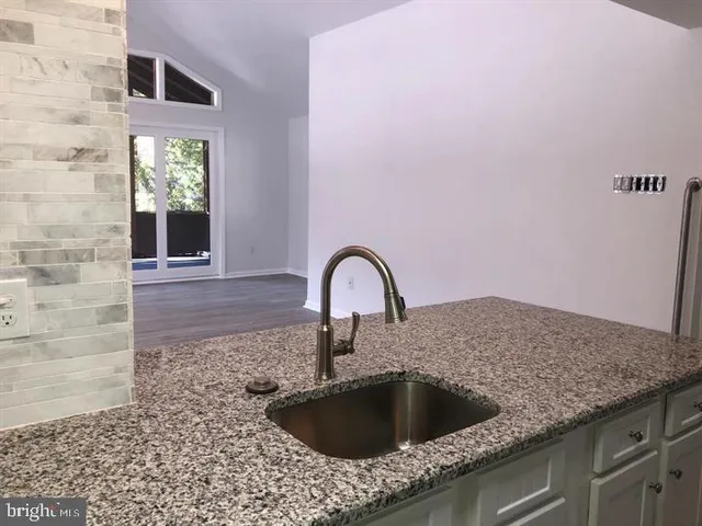 a kitchen with granite countertop a sink and a stove