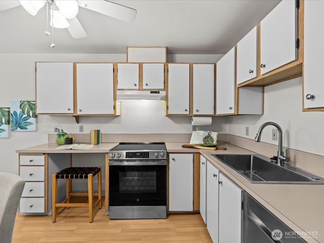 a kitchen with stainless steel appliances granite countertop a stove sink and cabinets