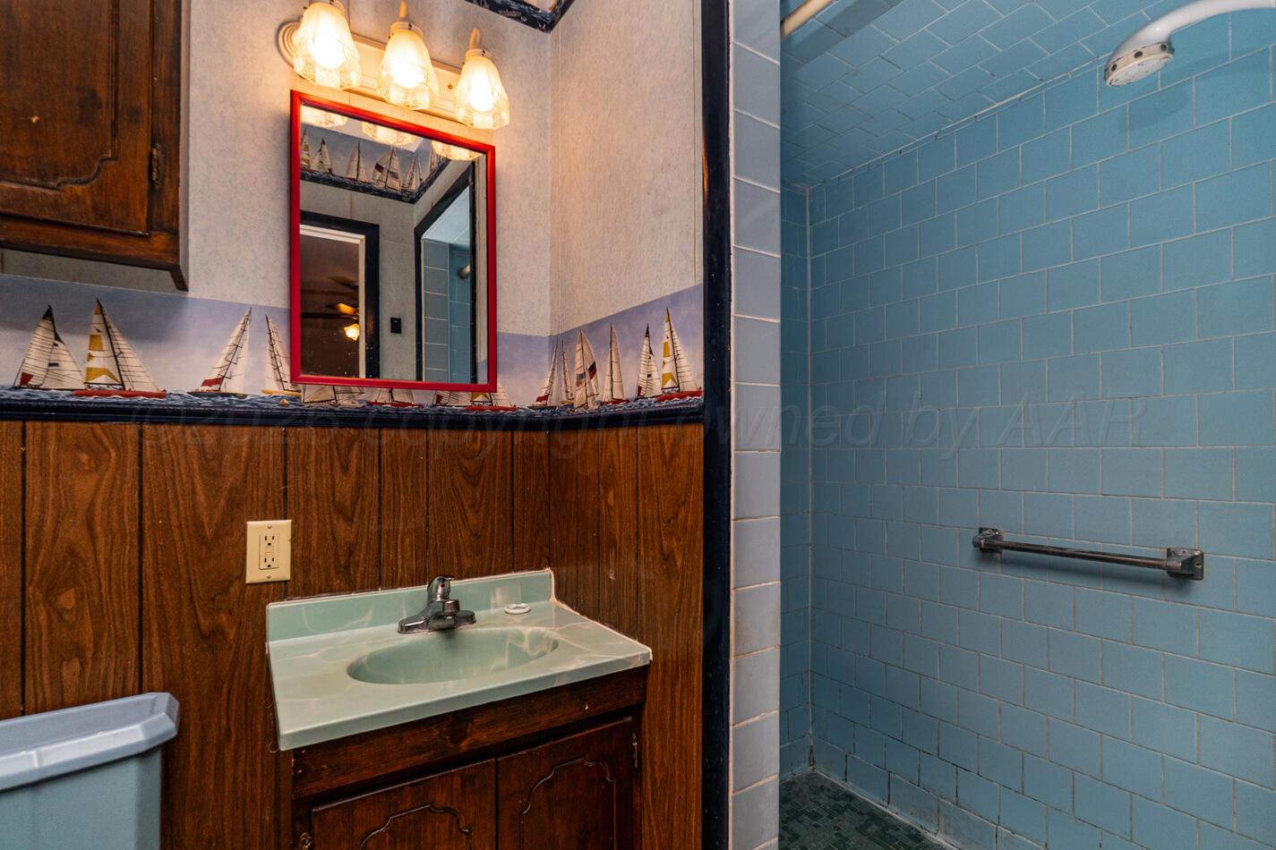 300 Mccarthy Street Borger, TX 79007 - Photo 20 of 31 a bathroom with a sink a mirror and shower