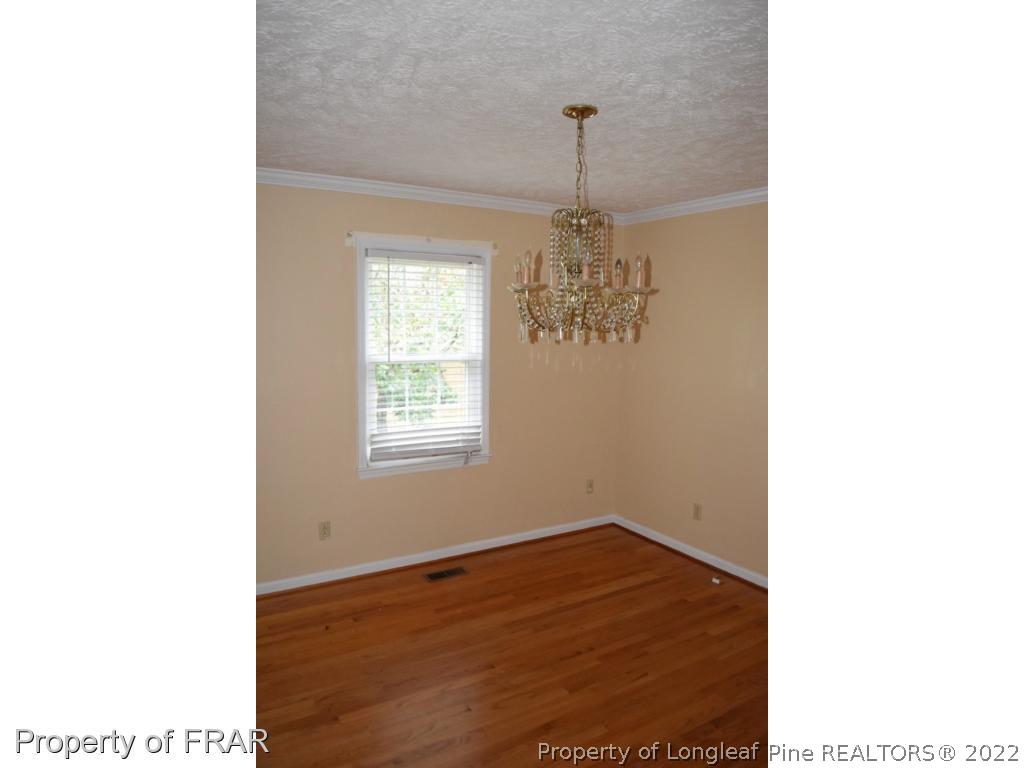 26861 Harold Morris Road Wagram, NC 28396 - Photo 4 of 24 a view of a room with a chandelier and wooden floor