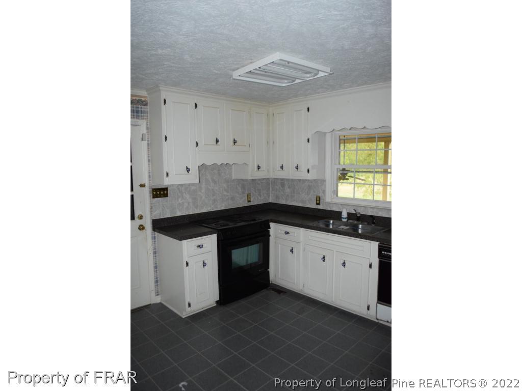 26861 Harold Morris Road Wagram, NC 28396 - Photo 6 of 24 a kitchen with granite countertop a sink and a stove