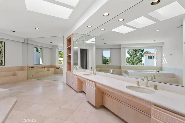 a large bathroom with a large mirror vanity and a sink