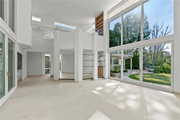 a view of a room with a large window and garden view