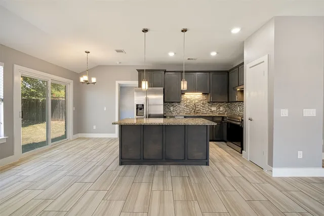 a kitchen with kitchen island a sink stainless steel appliances and cabinets