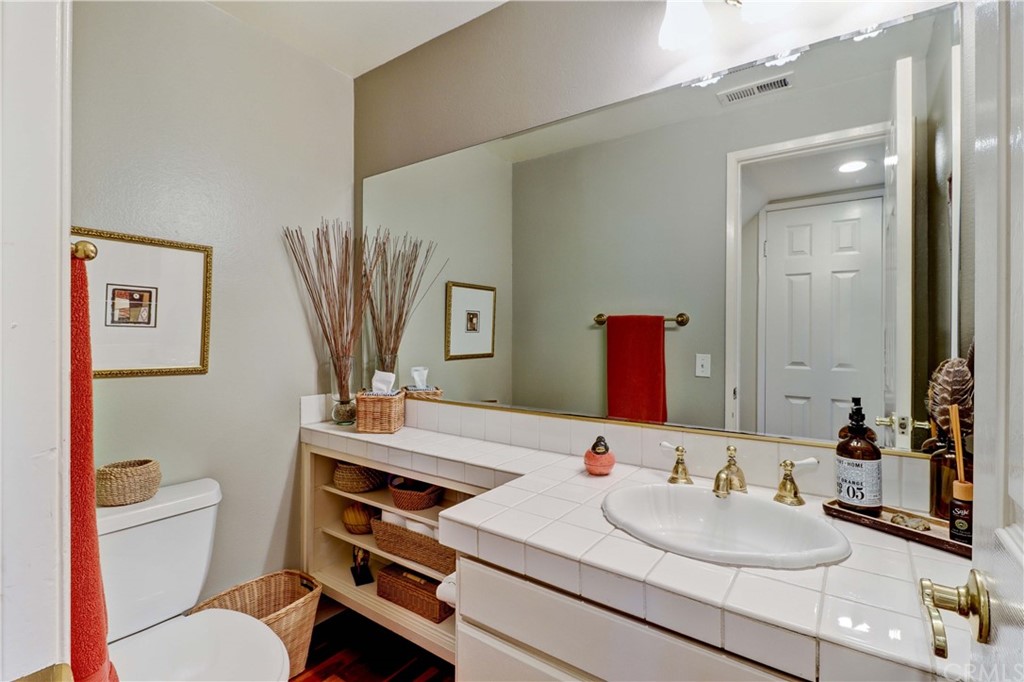 3 Sunflower, Unit 27 Irvine, CA 92604 - Photo 16 of 47 a bathroom with a sink vanity mirror and toilet