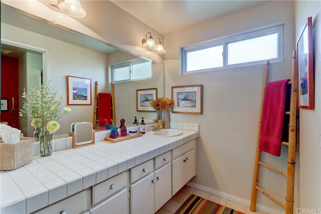 3 Sunflower, Unit 27 Irvine, CA 92604 - Photo 19 of 47 a bathroom with a sink a mirror and a shower