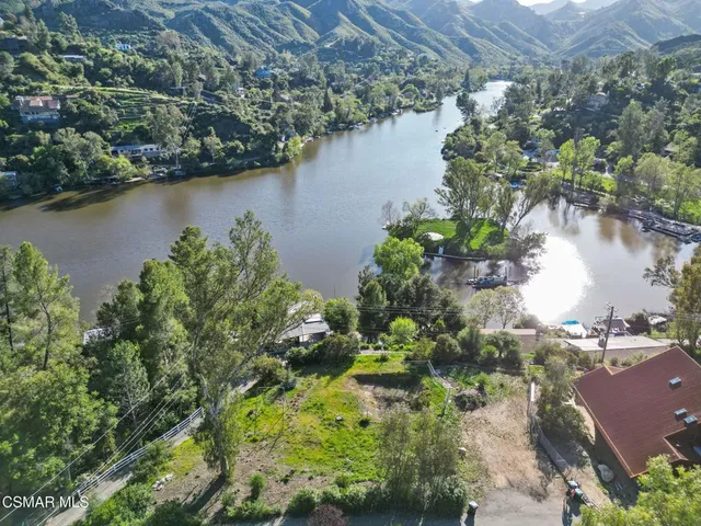 an aerial view of residential houses with outdoor space and lake view