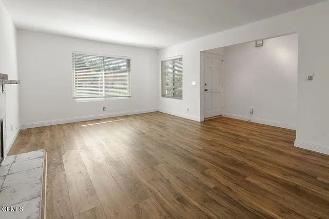 an empty room with wooden floor and fireplace