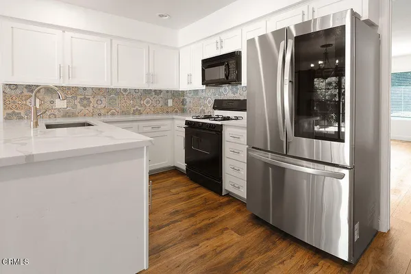 a kitchen with white cabinets appliances and a sink