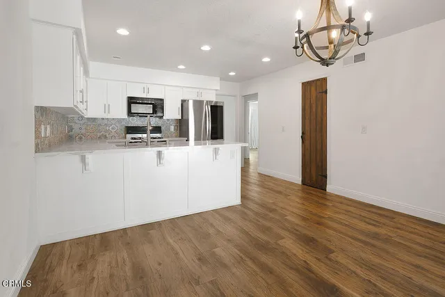 a kitchen with stainless steel appliances granite countertop a refrigerator and a stove top oven