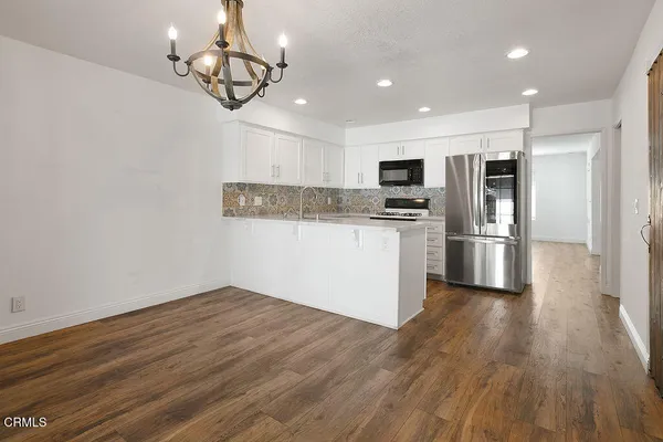 a view of empty room with wooden floor and window