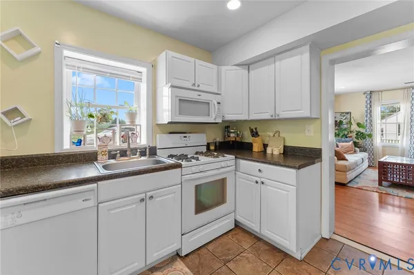 a kitchen with white cabinets and white appliances