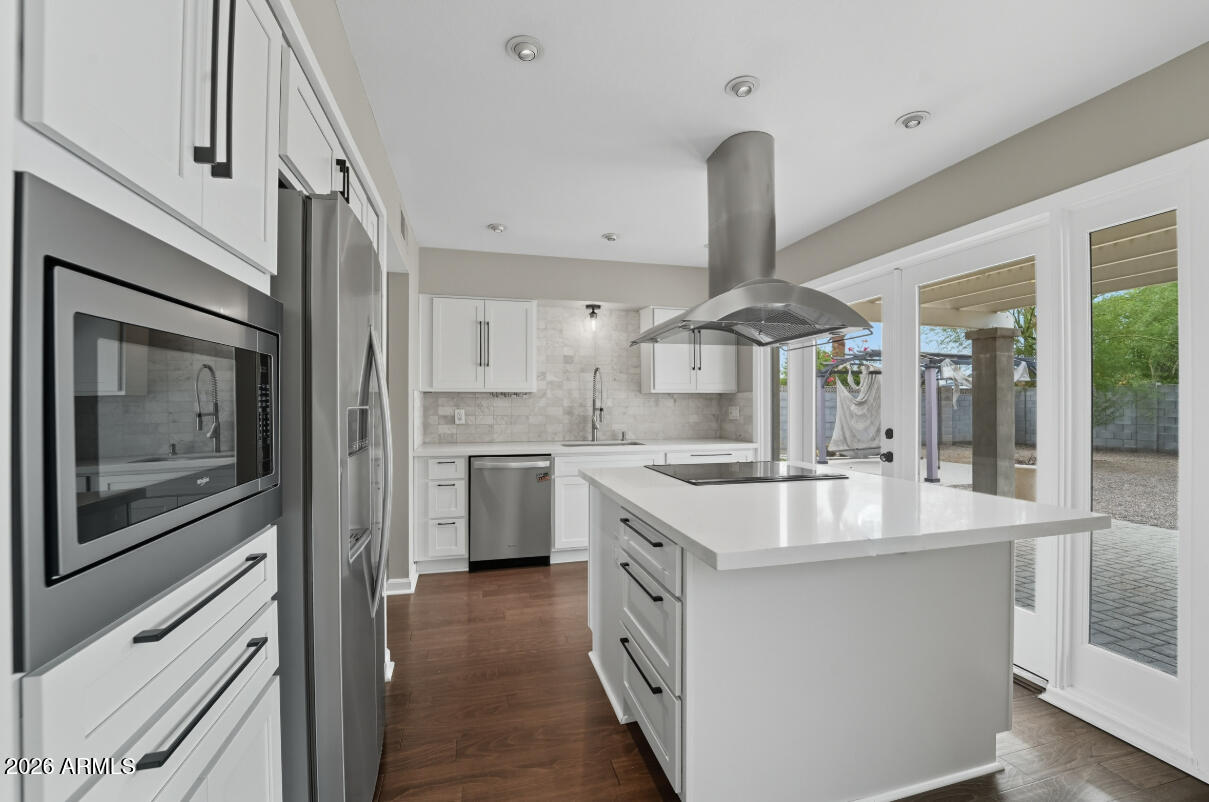 8437 East Thomas Road Scottsdale, AZ 85251 - Photo 12 of 55 a large kitchen with kitchen island a large counter space a sink appliances and cabinets