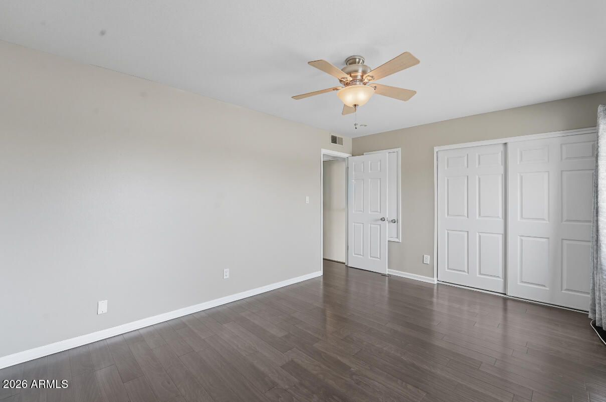 8437 East Thomas Road Scottsdale, AZ 85251 - Photo 34 of 55 a view of an empty room with wooden floor and a ceiling fan
