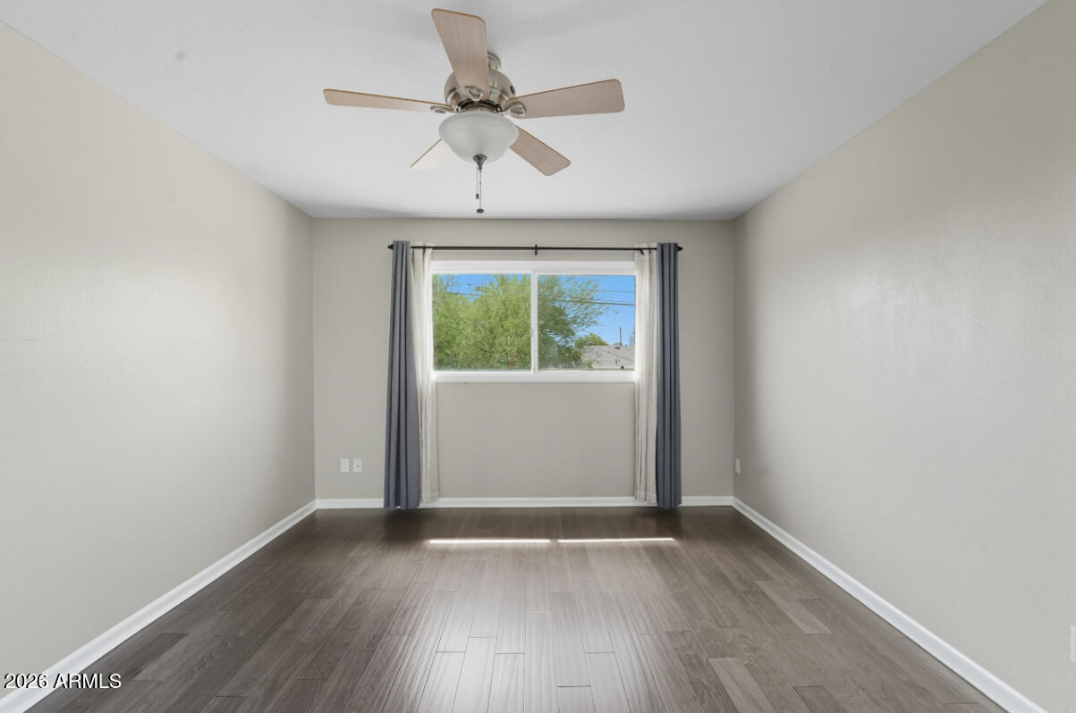 8437 East Thomas Road Scottsdale, AZ 85251 - Photo 37 of 55 an empty room with wooden floor chandelier fan and windows