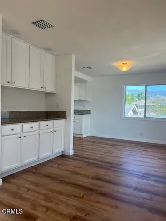 a kitchen with wooden floors and cabinets