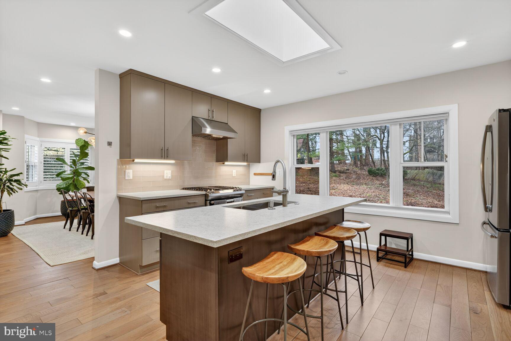 5908 17th Street Northwest Washington, DC 20011 - Photo 7 of 30 a kitchen with stainless steel appliances granite countertop a stove a refrigerator a sink a dining table and chairs with wooden floor