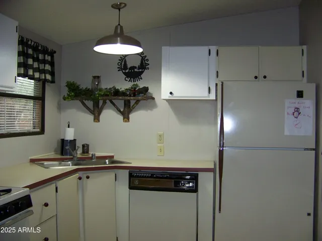 a kitchen with stainless steel appliances granite countertop a sink a stove and chairs