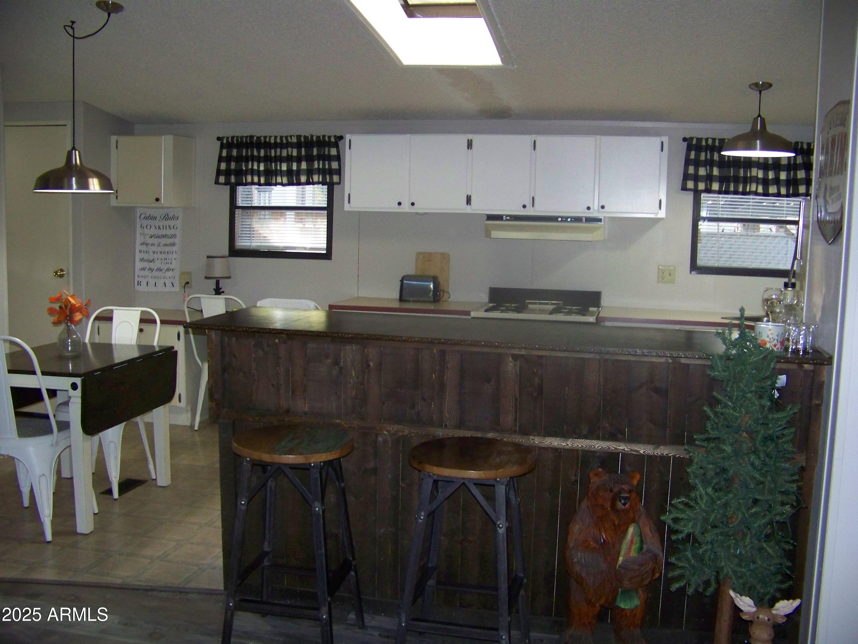 1167 White Tail Lane Pinetop, AZ 85935 - Photo 6 of 58 a kitchen with stainless steel appliances a stove a table and chairs in it
