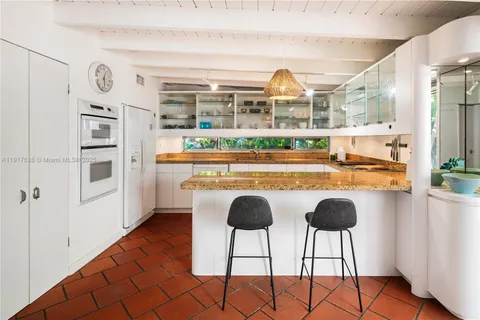 a living room with stainless steel appliances granite countertop a stove and a refrigerator