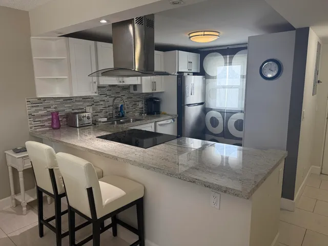 a kitchen with stainless steel appliances granite countertop a sink a stove and a refrigerator