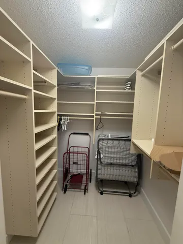 a view of walk in closet with clothes and shoes