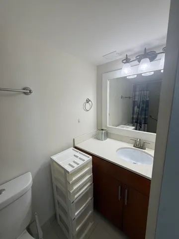 a bathroom with a sink toilet and mirror