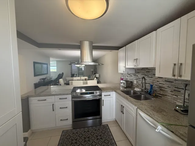 a kitchen with stainless steel appliances granite countertop a sink stove and cabinets
