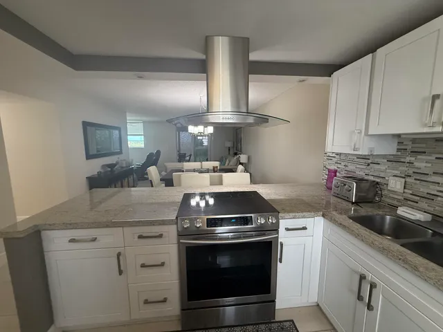 a kitchen with stainless steel appliances white cabinets and a stove top oven