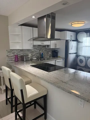 a kitchen with kitchen island a sink and a stove