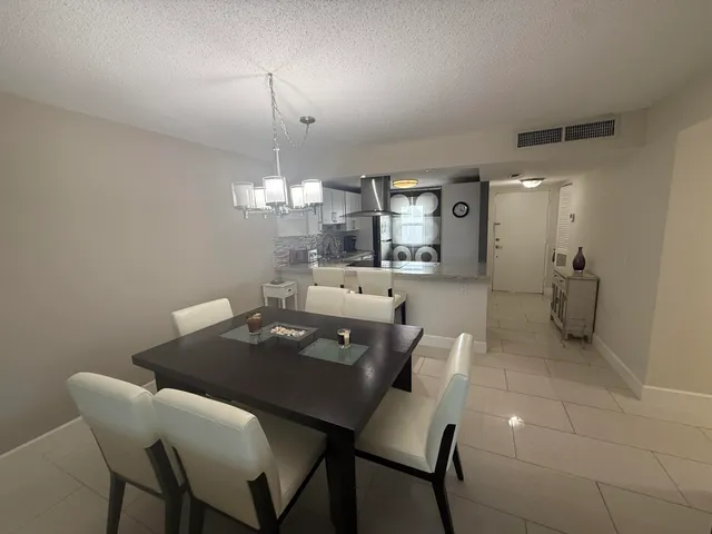 a view of a dining room with furniture and chandelier