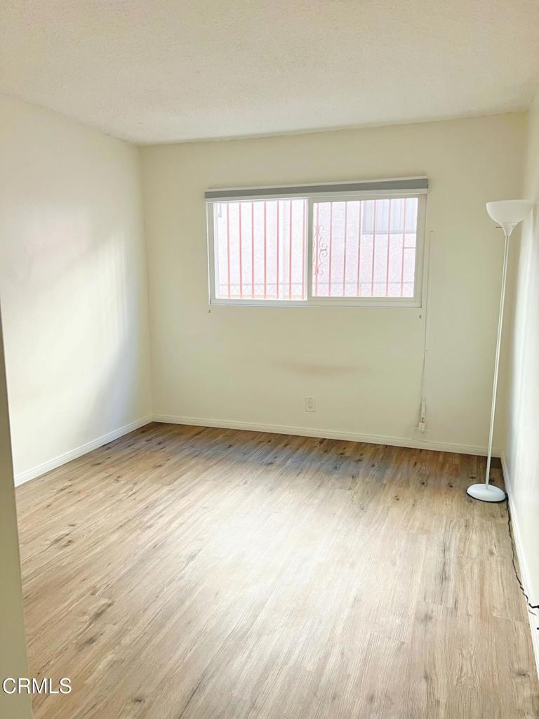 12256 Riverside Drive, Unit 2 Valley Village, CA 91607 - Photo 4 of 7 an empty room with wooden floor and windows