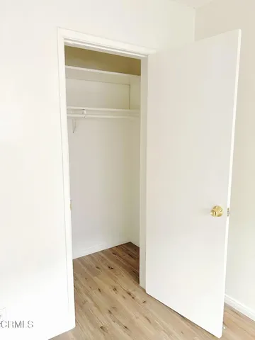 a view of walk in closet with wooden floor