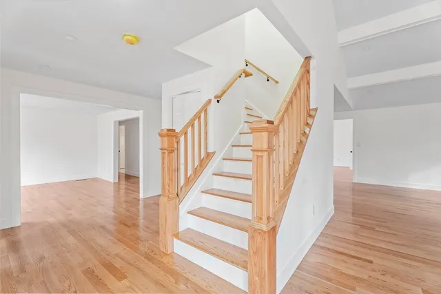 a view of a hallway with wooden floor and staircase