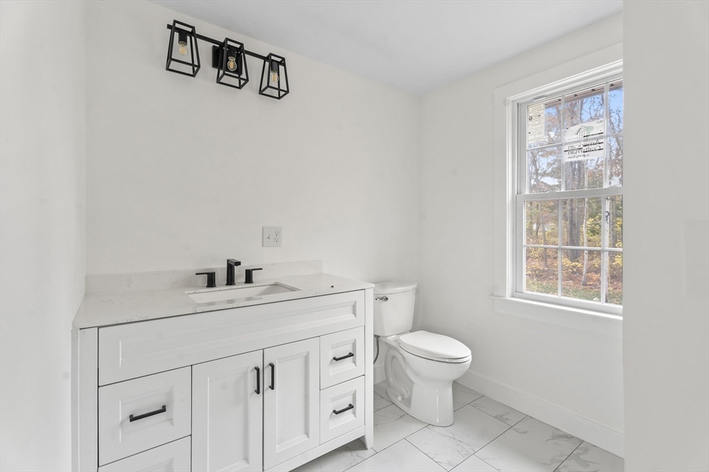 32 Laurel Lane Raynham, MA 02767 - Photo 18 of 30 a bathroom with a granite countertop sink a toilet and a window