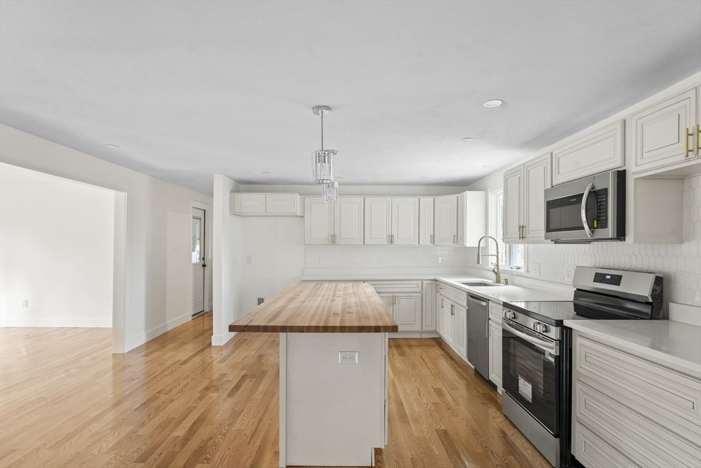 32 Laurel Lane Raynham, MA 02767 - Photo 5 of 30 a kitchen with granite countertop a sink and steel appliances