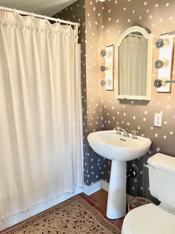 a view of a bedroom with wooden floor and windows