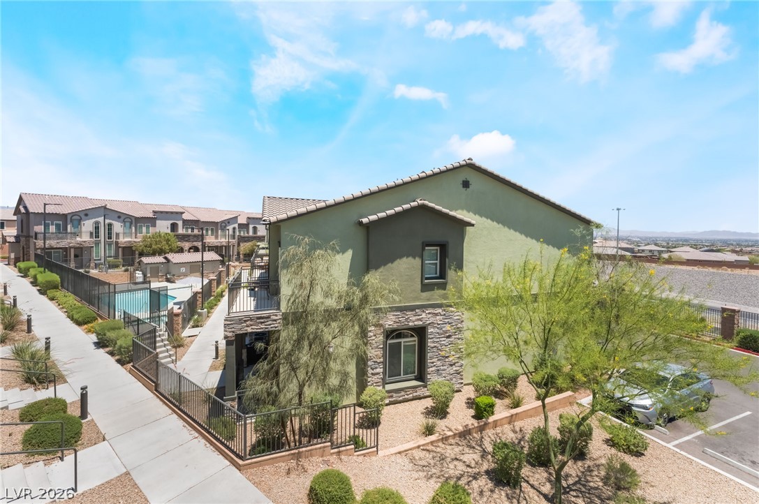 6432 Spring Jog Street Las Vegas, NV 89166 - Photo 28 of 61 Stone and stucco exterior building with an outdoor pool area and lush landscaping.